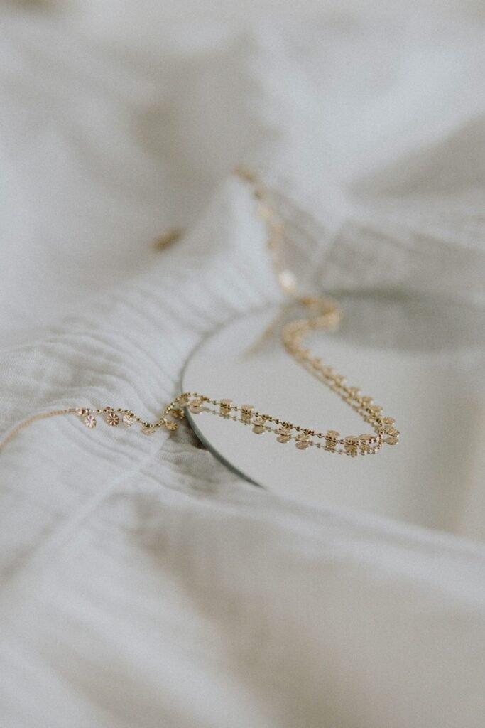 A fine gold chain resting on white linen