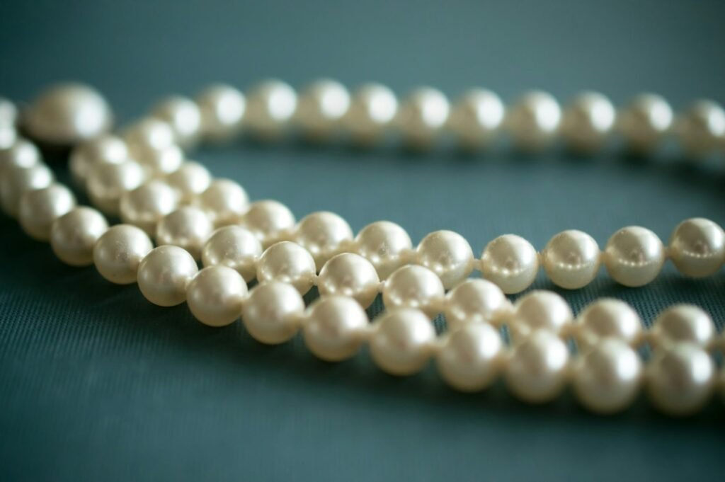 A strand of white pearls on grey linen